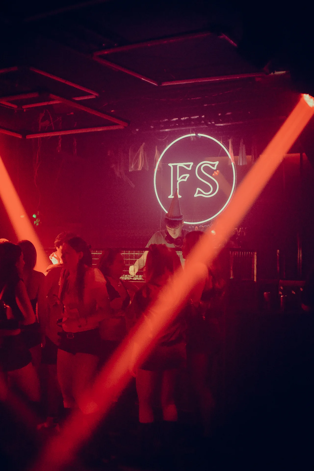 An orange beam cuts across the dancefloor beneath the glowing Frequency Shift roundel.