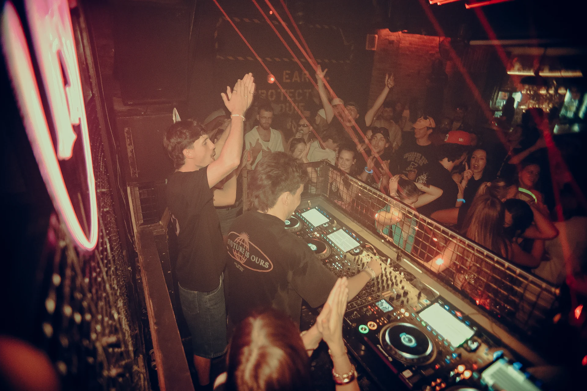 White lasers cut across a wide view of the DJ booth and packed front row.