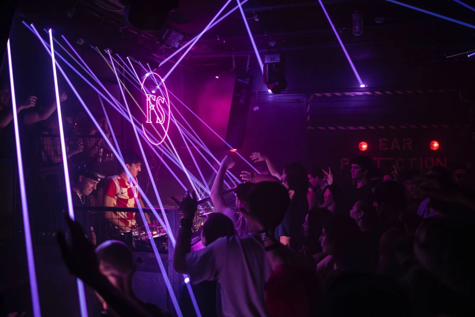 A guest films the crowd from above the DJ booth.