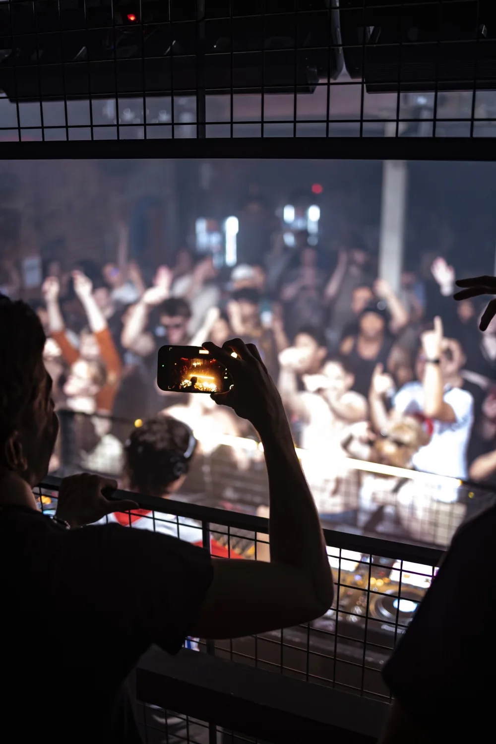 Two guests wearing blue and purple leis stand behind the DJ decks.
